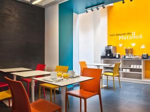巴黎梅塔罗斯酒店的餐厅设有桌椅和色彩缤纷的墙壁