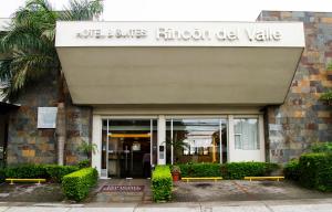 圣何塞Rincon del Valle Hotel & Suites的建筑前有两长椅的建筑
