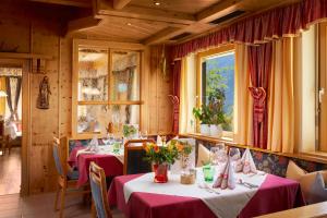 纽科琴格罗斯夫艾伯霍夫酒店的餐厅设有两张带红色桌布的桌子