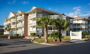 默特尔比奇默特尔海滩加勒比度假酒店的一座大型公寓楼,前面有棕榈树