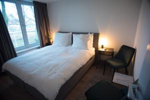 阿姆斯特丹B&B Gabriela Amsterdam的卧室配有床、椅子和窗户。