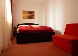 布拉迪斯拉发多奈特膳食公寓的一间卧室配有红色的床和椅子