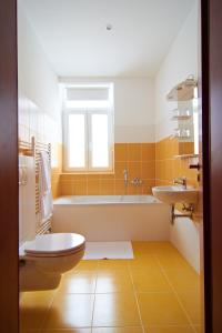 布拉迪斯拉发多奈特膳食公寓的带浴缸、卫生间和盥洗盆的浴室