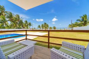 伊塔马拉卡Manga Verde Beach Residence的一个带两把椅子的阳台和一个游泳池