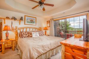 布兰森The Village At Indian Point Resort的一间卧室配有一张带吊扇和窗户的床。