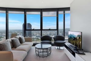 布里斯班Brisbane Skytower by CLLIX的客厅配有沙发、椅子和电视