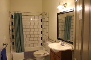 波特兰Northwest Portland Hostel的一间带水槽、卫生间和镜子的浴室