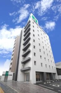 广岛广岛站前船只酒店 的上面有绿色标志的白色建筑