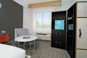 休斯顿Hotel Ylem的一间酒店客房,配有一张床铺、一张桌子和一台电视