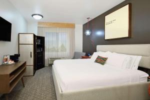 休斯顿Hotel Ylem的酒店客房设有一张白色大床和一张书桌