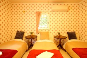 轻井泽轻井泽佐藤奴库利旅馆的客房设有两张床、两张桌子和一扇窗户。