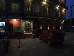 焦特布尔Hotel Centre Point的一辆红色的汽车在晚上停在房子前面
