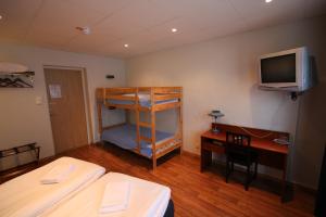 永比林尼亚酒店的一间卧室配有一张双层床和一张书桌及电视