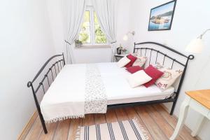 克勒克Apartments Mediterranean House的卧室配有带红色枕头的白色床