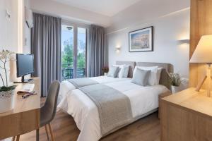 雅典敏纳夫拉酒店的酒店客房设有一张大床和一张书桌。