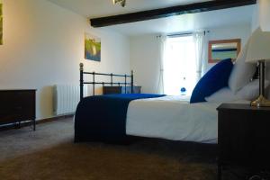 Saint-Jean-des-EssartiersL'Auberdiere的一间卧室配有蓝色和白色床单