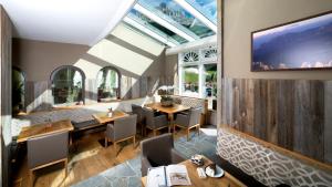 奥贝雷根索那尔普酒店的一间带桌椅的餐厅以及墙上的电视