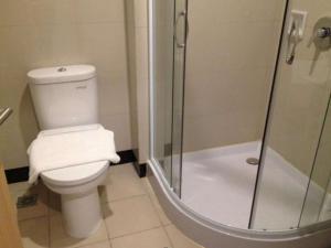 名古屋巴淡岛商务酒店的一间带卫生间和玻璃淋浴间的浴室