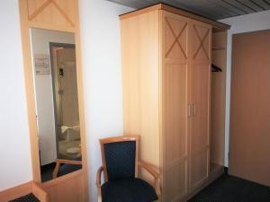 汉诺威NEAR BY酒店的一间带椅子和衣柜的房间