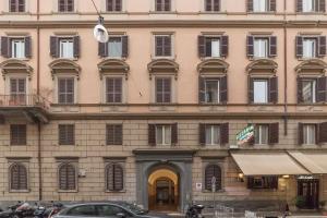 罗马Appartamento Via Genova的一座大型建筑,前面有汽车停放