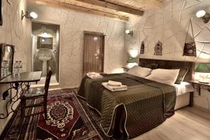 格雷梅Days inn Cappadocia的一间卧室配有一张大床、一张桌子和一张桌子。