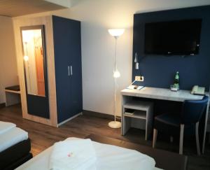 汉诺威NEAR BY酒店的酒店客房设有一张桌子和一台墙上的电视。