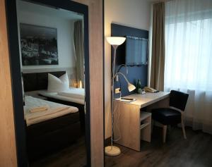 汉诺威NEAR BY酒店的酒店客房配有书桌、床和镜子