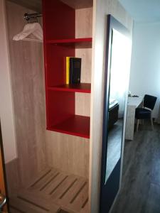 汉诺威NEAR BY酒店的衣柜,配有红色架子和镜子