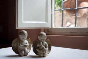 卢卡阿拉科特德洋杰里酒店的两个天使像像坐在窗边的桌子上