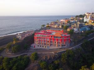 圣菲利佩Hotel Ocean View & Restaurante Seafood的海边山丘上的红色建筑