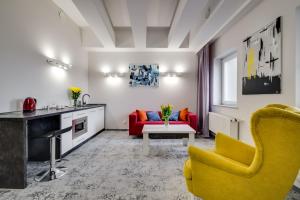 卡托维兹SAVOY Mariacka Apartments的客厅配有黄色椅子和红色沙发