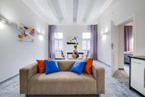 卡托维兹SAVOY Mariacka Apartments的客厅配有蓝色和橙色枕头的沙发