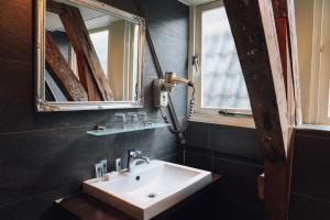 阿姆斯特丹角落之家酒店的一间带水槽和两面镜子的浴室