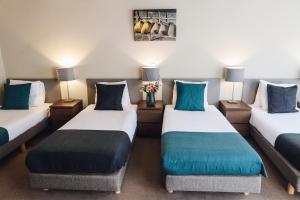 阿姆斯特丹角落之家酒店的客房配有两张带蓝色枕头的床。