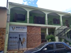 阿帕雷西达Pousada Vitória的前面有停车位的建筑
