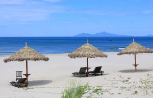岘港Motel Thanh Long的海滩上的一组椅子和遮阳伞