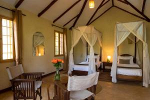 阿鲁沙Kili Villa Kilimanjaro Luxury Retreat的一间卧室配有两张床和一张桌子及椅子