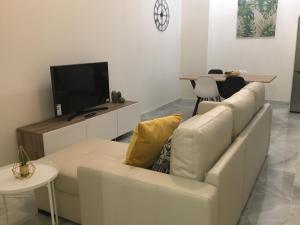 加的斯Apartamento nuevo en casa tipo palacio的客厅配有白色沙发和电视