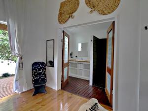 卢甘维尔Sails Beach House的客厅配有椅子,铺有木地板