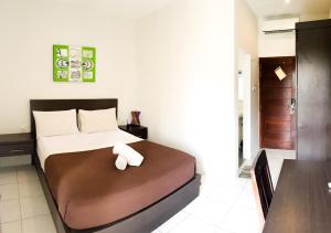 乌鲁瓦图纳齐拉酒店的一间卧室配有一张床,床上有毛巾