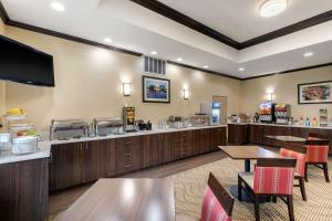 雪松山Comfort Inn & Suites Cedar Hill Duncanville的一间带桌椅和食品柜台的餐厅