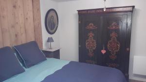 利克维Au fil de l'écriture - Appartement sur la Route des Vins à riquewihr的一间卧室设有蓝色的床和木门