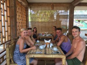 吉利特拉旺安Island Beach Bungalow的一群坐在餐厅桌子上的人