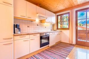 施图拜河谷新施蒂夫特Ferienwohnung Mair的厨房配有白色橱柜和地板上的地毯