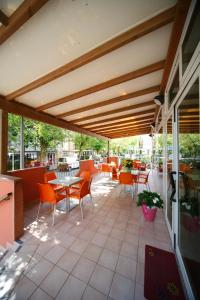 里米尼史波特酒店的一座庭院,里面设有橙色的椅子和桌子