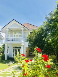 美奈Villa Mui Ne Phan Thiet SeaView的院子里有红色花的白色房子
