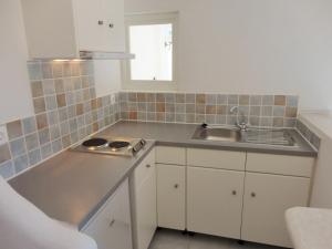 洛加拉斯Meltemi Studios and Apartments的厨房配有白色橱柜和水槽