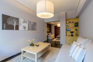 雅典Tranquil Central Apt, behind Athens Caravel Area的客厅配有桌子和沙发