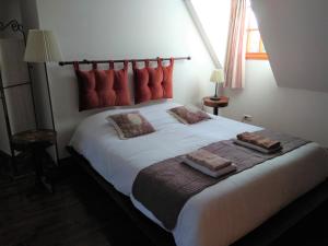 Vernou-sur-Brenne兰德斯磨坊住宿加早餐酒店的卧室配有带红色枕头的大型白色床