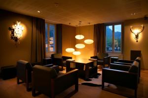 迈林根Victoria - Alpine Boutique Hotel & Fine Dining的一间设有桌椅和吊灯的等候室